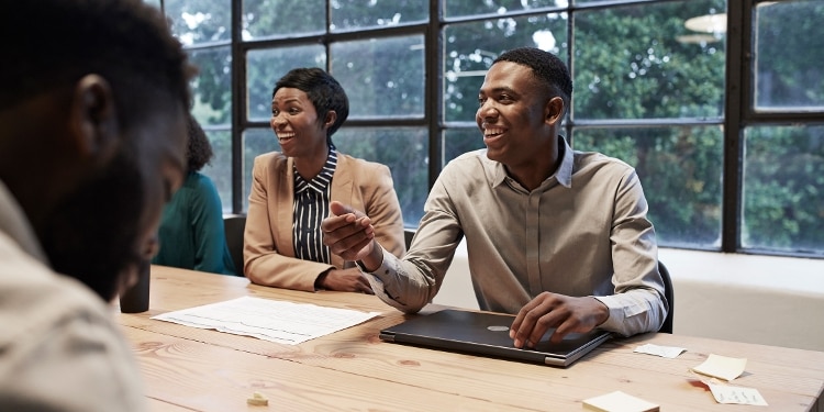 Two people sit at conference table