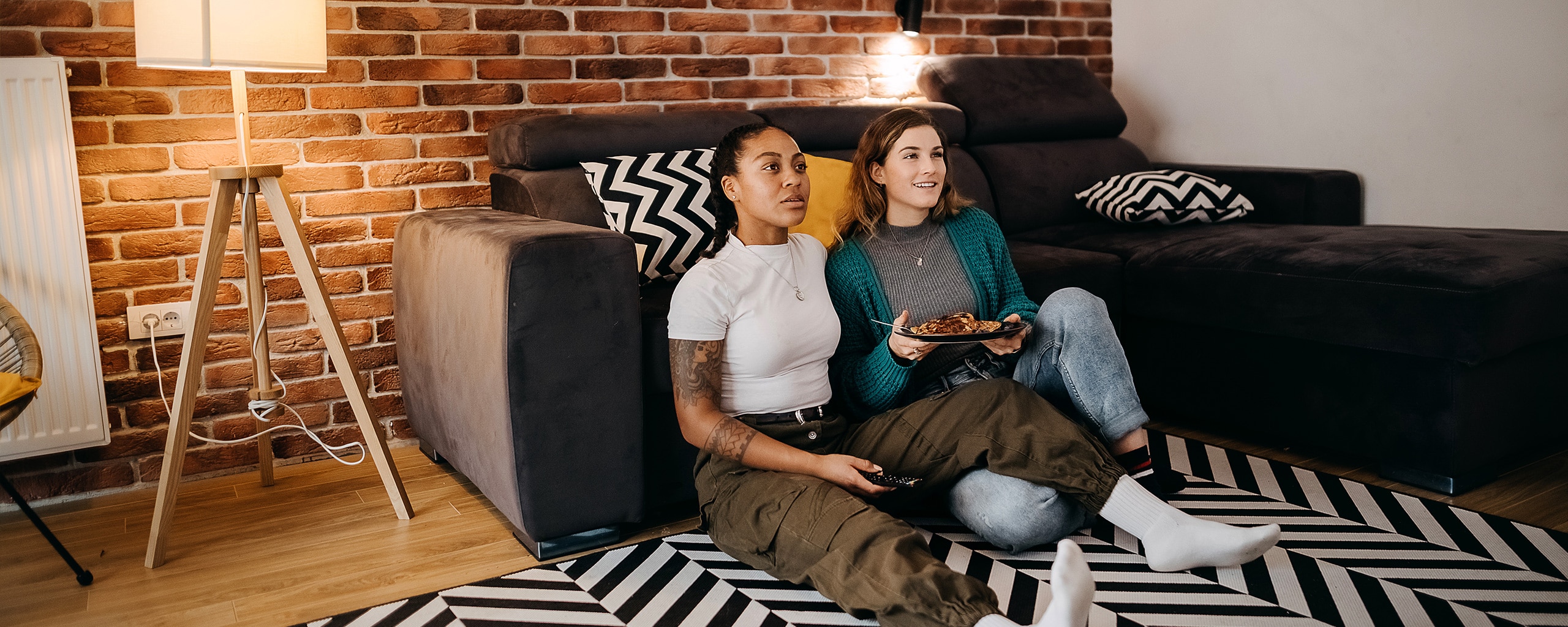 A couple eats dinner and watches TV in their rent-to-own home.